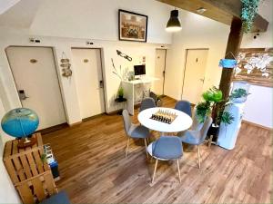 Zimmer mit einem Tisch, Stühlen und einem Schreibtisch in der Unterkunft VIVA Hostel in Chur