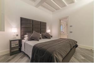 a bedroom with a large bed with a large headboard at Reale Luxury Home in Rome