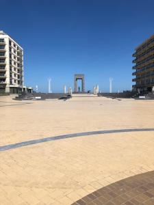 a shadow of a person on a large plaza with buildings at Residentie Noordhinder in De Panne