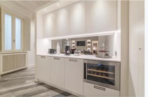 a kitchen with white cabinets and a stove top oven at Reale Luxury Home in Rome