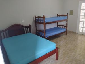 圣塞巴斯蒂安Sobrado Refúgio do Mar - Aconchego e Conforto perto das Praias的客房设有两张床和一张双层床。