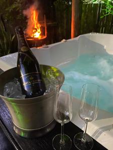 a bottle of wine in a bucket next to two wine glasses at El Roi Guest Lodge in White River