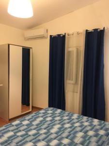 a bedroom with a blue bed and a mirror at Scibetta's B&B in Taranto