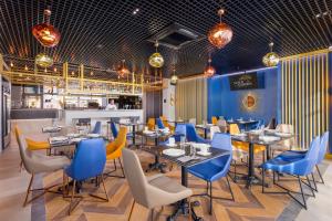 un restaurante con mesas y sillas y un bar en GOLD inn GARDEN en Krasnodar