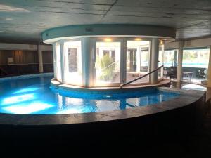 a large swimming pool in a building with a dome at Linda Bay 202 in Mar de las Pampas