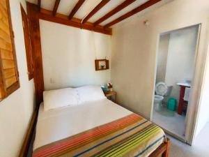 a small bedroom with a bed and a bathroom at Quatro palos in Rincón