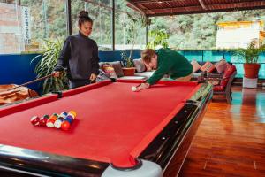 a man and a woman playing a game of pool at Nativus Hostel Machu Picchu in Machu Picchu