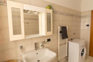 a bathroom with a sink and a toilet and a mirror at Casa Lena in Ledro +12 photos
