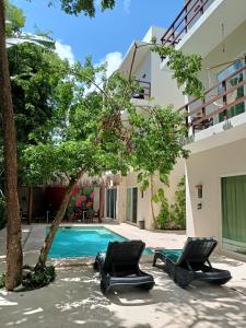 a resort with two chairs and a swimming pool at Tulum Nah in Tulum