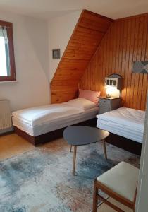 1 Schlafzimmer mit 2 Betten, einem Tisch und einem Stuhl in der Unterkunft Haus mit Ausblick 3 Schlafzimmer in Wilkau-Haßlau