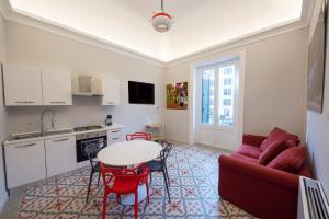 a living room with a red couch and a table at Suite del Ponte Normanno in Palermo