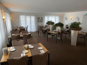 Hotel Europe Brig في بريغ: غرفة طعام مع الطاولات والكراسي وسيدكس سيد
