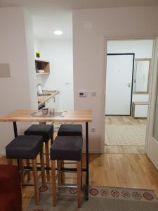 a kitchen with a wooden table with stools and a mirror at VIP 2 Apartment in Visoko