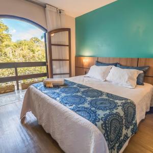 a bedroom with a bed and a large window at Hotel Sonnet by Estância Santa Cruz in Curitiba