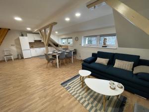 salon z niebieską kanapą i stołem w obiekcie Apartmány Herc w mieście Jáchymov