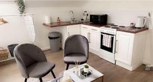 a kitchen with two chairs and a stove at CityNights Studios with Free Parking in Liverpool +81 photos