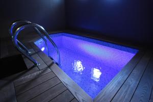 a swimming pool with purple lighting in a room at Jēkaba sēta in Kuldīga