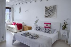 Habitación blanca con cama y sofá en Ocra Apartment, en Yaiza