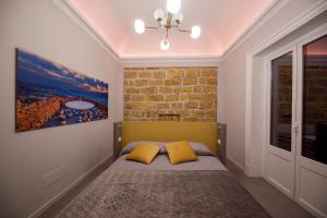 sypialnia z łóżkiem z 2 żółtymi poduszkami w obiekcie Suite del Ponte Normanno w mieście Palermo