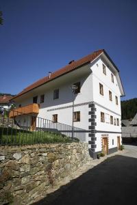 Casa blanca grande con pared de piedra en Juvanova hiša (all house), en Luče