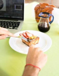 une personne mange un morceau de gâteau sur une assiette dans l'établissement Hotelito Los Sueños, à Sayulita