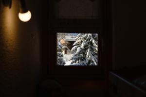 una imagen de una ventana en una habitación con árboles nevados en Les Alpages 73 - Les Saisies, en Les Saisies