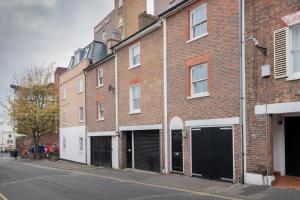 a brick building with black garage doors on a street at Modern, 2 Bdrm House Town Centre, North Laine Sleeps 6 in Brighton & Hove