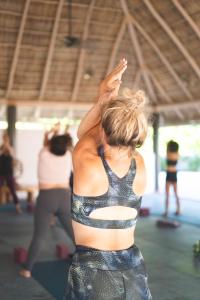 a woman standing in a gym with her arm in the air at Hotelito Los Sueños in Sayulita