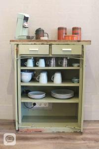 a shelf filled with dishes and pots and pans at Villa Pats in Gilze