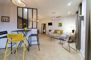 kuchnia i salon z żółtymi krzesłami i stołem w obiekcie Appart Hotel Eugenie w mieście Louhans