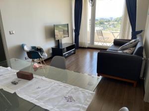 a living room with a glass table and a television at Departamento Valdivia in Valdivia