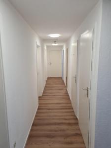 pasillo largo con paredes blancas y suelo de madera en Hotel Lamm en Stuttgart