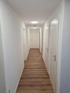 pasillo largo con paredes blancas y suelo de madera en Hotel Lamm, en Stuttgart