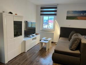 a living room with a couch and a flat screen tv at Apartman Centrum 403 in Ústí nad Labem