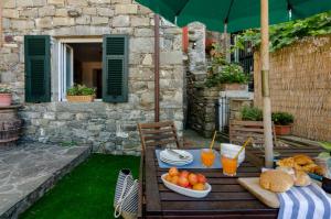 a table with food and drinks on a patio at La Casetta Rossa in Corniglia