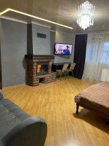sala de estar con chimenea y TV de pantalla plana en LIKE HOTEL en Kolomiya