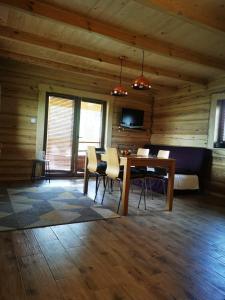 a dining room with a table and chairs in a cabin at Hacjenda u Olendra in Piecki