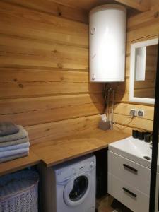 a kitchen with a washing machine and a sink at Hacjenda u Olendra in Piecki