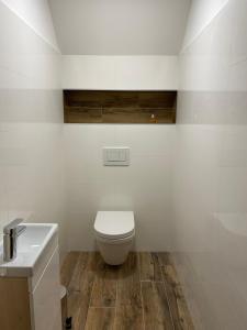 a white bathroom with a toilet and a sink at Yes Dream apartment in Jeseník