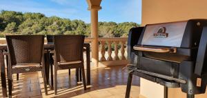 a balcony with chairs and a grill on a porch at ROMANTICA Voramar in Cala Romàntica