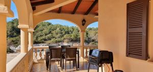 a porch with chairs and a television on a balcony at ROMANTICA Voramar in Cala Romantica