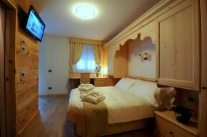 1 dormitorio con 1 cama con toallas en Agritur Melissa, en Croviana