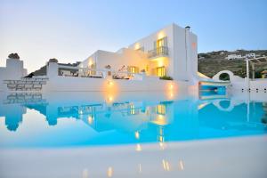 uma villa com piscina à noite em Paolas Sunset em Agios Stefanos