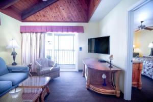 a living room with a couch and a tv at Soundside Holiday Beach Resort in Pensacola Beach