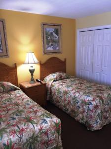 a hotel room with two beds and a lamp on a table at Soundside Holiday Beach Resort in Pensacola Beach