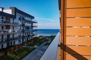 a view of the beach from the balcony of a building at BALTIC VIEW Supreme Apartment GARDENIA in Dziwnów