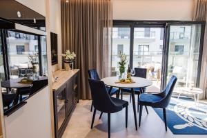 a dining room with a table and chairs at BALTIC VIEW Supreme Apartment GARDENIA in Dziwnów