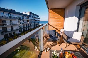 a balcony with two chairs and a view of the ocean at BALTIC VIEW Supreme Apartment GARDENIA in Dziwnów +3 photos