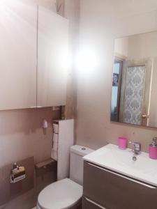 W łazience znajduje się toaleta, umywalka i lustro. w obiekcie Bella Vista w mieście Almería
