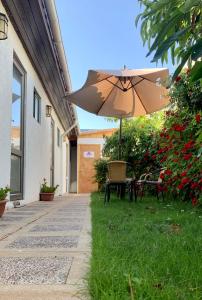 an umbrella sitting in the grass next to a building at Hostal del Valle in Santa Cruz